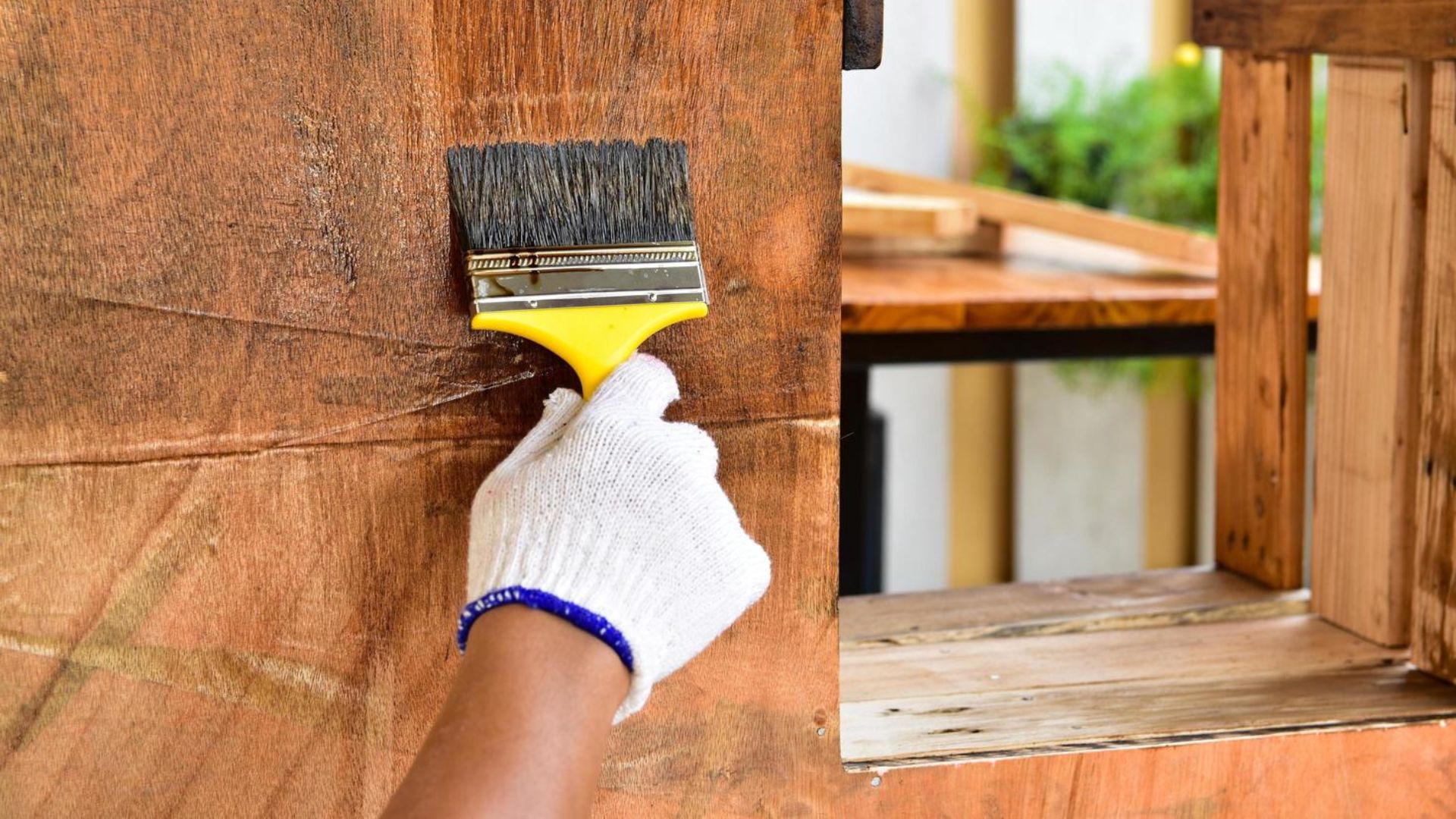 Persona aplicando producto sobre madera con pincel